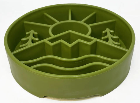 The SodaPup Great Outdoors Design EBowl Enrichment Slow Feeder Bowl for Dogs is a green, round silicone feeder featuring sun, mountain, tree, and wave designs to enhance your dogs mealtime enrichment.
