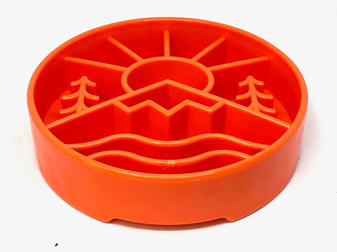 The SodaPup Great Outdoors Design EBowl is an orange circular slow feeder for dogs with raised mountains, trees, a sun and wavy lines to boost enrichment.