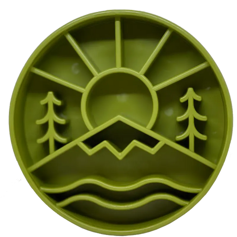 The SodaPup Great Outdoors Design EBowl Enrichment Slow Feeder Bowl for Dogs is a green, round plastic bowl featuring a sun above mountains, two trees, and wavy water lines with raised edges to separate sections for enrichment feeding.