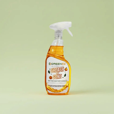 A GreenEZ® Grease Be Gone – Non-Toxic Degreaser Spray bottle with orange liquid is shown against a plain light green background. Made in the USA, this eco-friendly cleaner is perfect for removing grease safely.