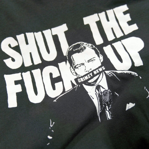 A graphic on the Collab Tee: Grimzy-STFU by American Lictor shows a man in a suit at a mic, “SHUT THE FUCK UP” above him, and his mouth obscured by Grimzy News text. Size guide includes info on compacted ring-spun cotton.