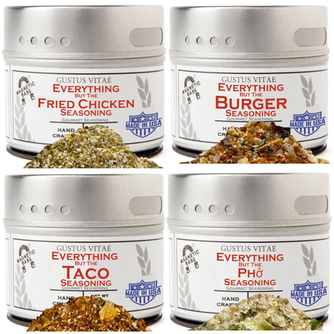 The Gustus Vitae Everything but the Food Truck Favorite Flavors Collection includes four tins—Everything But the Fried Chicken, Burger, Taco, and Pho—with piles of each gourmet seasoning mix in front of their respective tins.