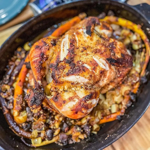 A whole chicken with crispy Garlic Pepper Rub from Gustus Vitae’s Must Have Kitchen Basics | Set of 4 is roasted alongside golden carrots and celery, blending savory flavors for a delicious meal.