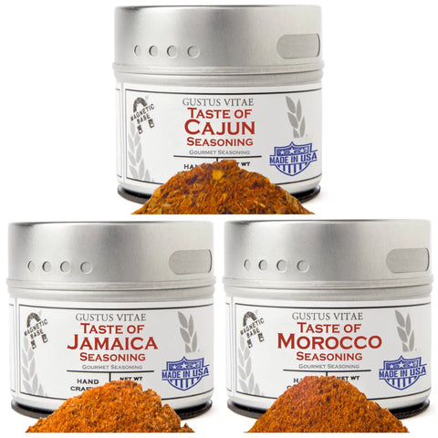 Three tins from Gustus Vitae’s Fiery Flavors Gourmet Seasoning and Rub Collection are shown with piles of reddish-brown spice blends in front and “Made in USA” labels visible, making an ideal spice rub set.