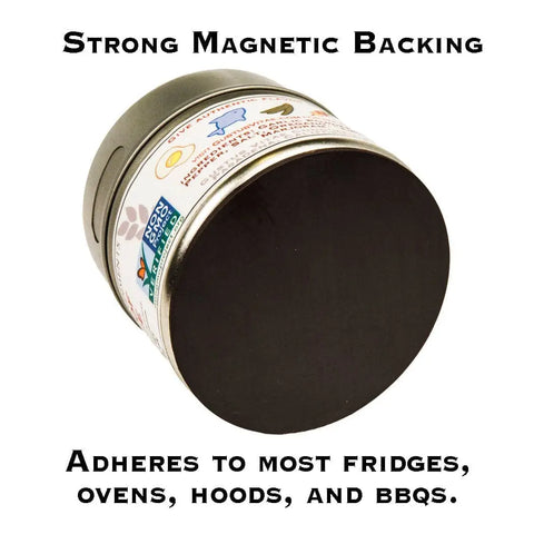 A round container from Gustus Vitae’s Gourmet BBQ Steak & Beef Seasoning Gift Set - Six Pack features a solid black magnetic backing, keeping your favorite seasonings handy on fridges, ovens, hoods, and BBQs. Text: Strong Magnetic Backing.