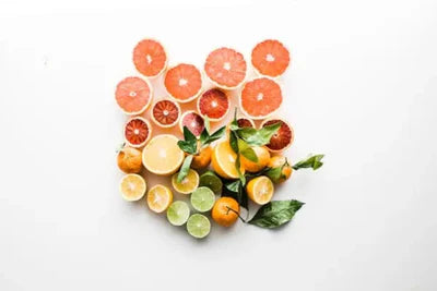 Assorted citrus fruits arranged in a circular pattern on a white background