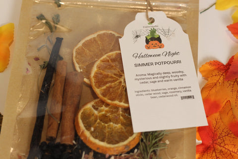 Forev'Herbs Halloween Night Simmer Potpourri features dried orange slices, autumn spices, cinnamon sticks, and vanilla beans in an eco-friendly bag with a tag showing the aroma and ingredients, finished with decorative autumn leaves.