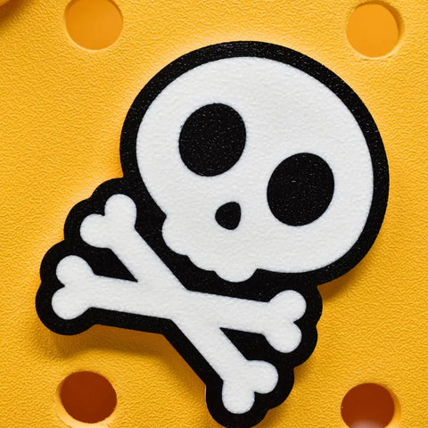 The FRESHe BAGLETS Halloween Skull & Bones Charm by Chatelet Manufacturing is a cute white skull and crossbones with black outline, compatible with all rubber tote bags—perfect as a festive accessory for Halloween. Made in the USA.