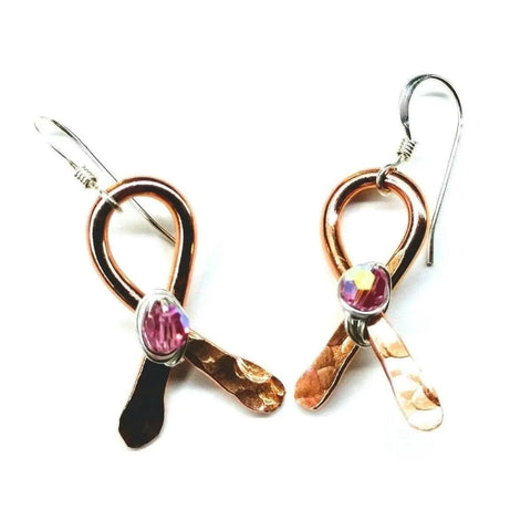 Copper Breast Cancer Awareness Ribbon Earrings by Alexa Martha Designs feature handcrafted copper loops with hammered tails and pink gemstone accents, perfect for showing support. Displayed against a white background.