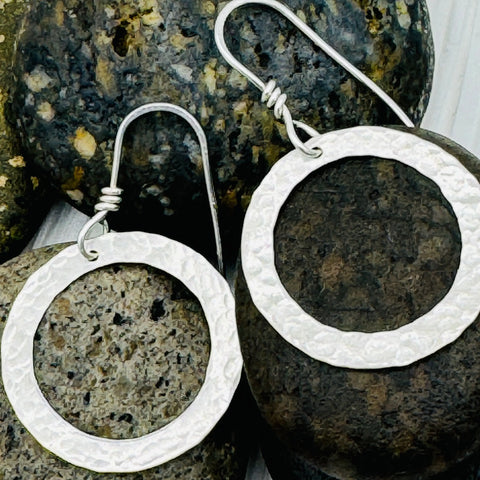 JANECKA Sterling Silver Hand Forged Hoop Earrings by Janecka—artisan-crafted with wire hooks and a rustic, hammered finish. Displayed with textured stones, theyre perfect for fans of handcrafted jewelry.