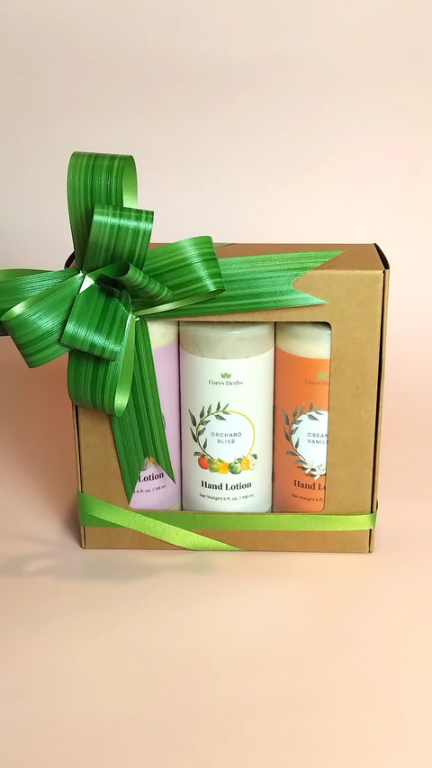 The Forev'Herbs Hand Lotion Gift Set features three pastel bottles with a large green ribbon, set against a light peach background—an ideal seasonal gift.