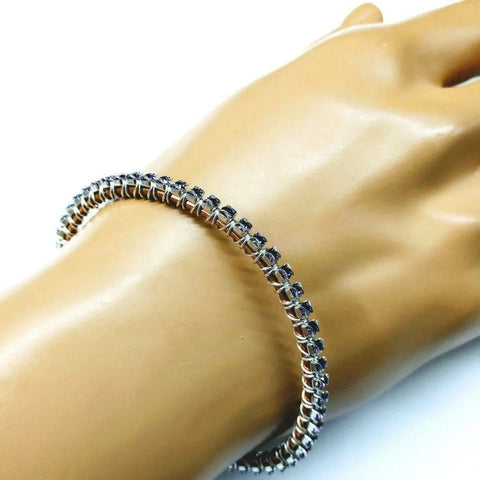 The Wire Wrapped Amethyst Crystal Tennis Bracelet Bangle by Alexa Martha Designs is showcased on a mannequin’s hand, highlighting its smooth, elegant design and secure clasp—ideal for fans of handmade crystal jewelry.