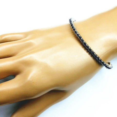 A mannequin hand displays the Alexa Martha Designs Wire Wrapped Amethyst Crystal Tennis Bracelet Bangle, featuring dark amethyst stones in a single row for an elegant, minimalist look against a plain white background.