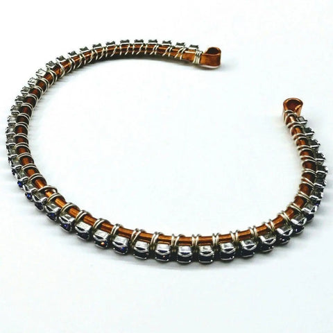 A Wire Wrapped Amethyst Crystal Tennis Bracelet Bangle by Alexa Martha Designs is displayed in a semi-circle on a white background.