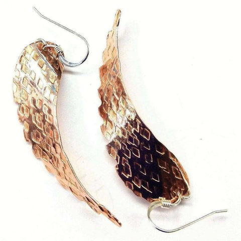 The Copper Hammer Pattern Sculpted Angel Wings Earrings by Alexa Martha Designs feature textured, copper-toned wings and silver hooks, showcased on a white background.