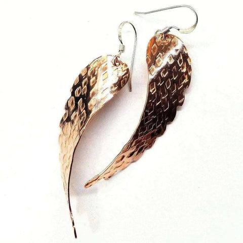 Copper Hammer Pattern Sculpted Angel Wings Earrings by Alexa Martha Designs feature handcrafted, textured angel wings with a shiny finish, each hung from a simple hook.