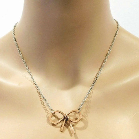 The Alexa Martha Designs Wire Wrapped Copper Bow Tie Silver Chain Necklace is shown on a mannequin bust against a plain background.