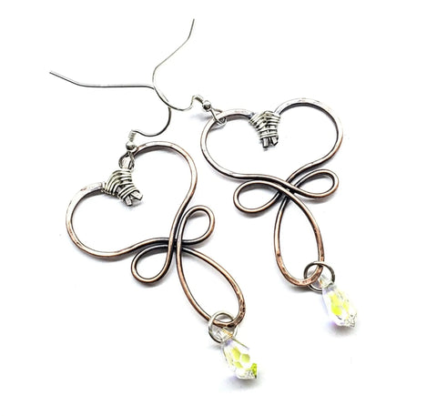 The Crystal Drop Copper Heart Earrings by Alexa Martha Designs feature handmade copper hearts with loops, delicate wrap detailing, and clear teardrop beads hanging from each earring.