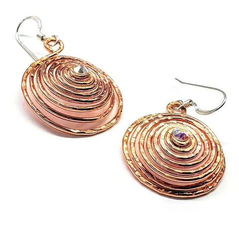 Alexa Martha Designs Crystal Embedded Copper Spiral Hoop Earrings feature a rose gold spiral design, each set with a small gemstone at the center and finished with fishhook ear wires.