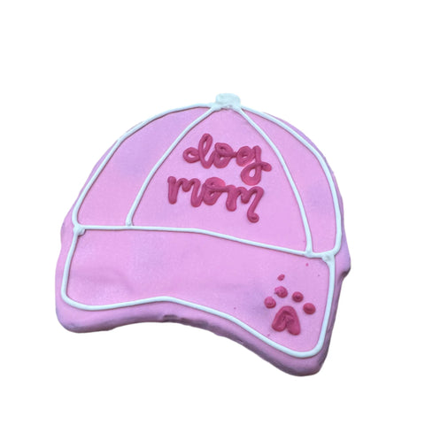 The Dog Mom Hat Cookie by Dogtown Bakery is a pink, hat-shaped artisan treat decorated with white and dark pink icing, featuring dog mom and a paw print—making it a delightful personalized gift for pet lovers.