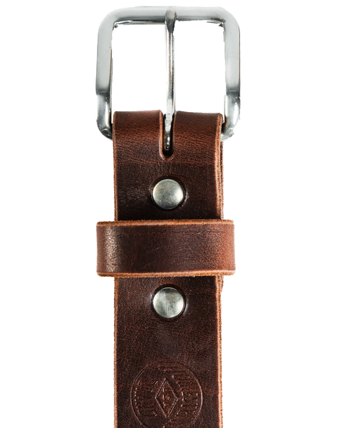 A close-up of the Essential Leather Belt No. 1508 by Homestead Brand shows its brown leather, solid brass buckle, two metal rivets, and stamped logo near the end, displayed vertically on a white background. Proudly made in the U.S.A.