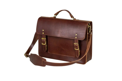 The Urban Southern Executive Briefcase is a brown full-grain leather satchel with a top handle, adjustable shoulder strap, front flap secured by two buckles, and gold-tone hardware, shown on a white background.