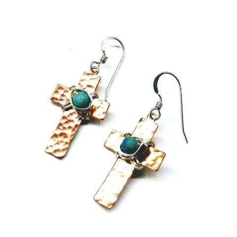 The Hammered Copper Cross Earrings With Turquoise Beads by Alexa Martha Designs feature handcrafted hook backs and round turquoise accents, beautifully displayed on a white background.