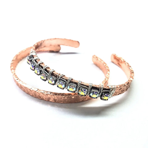 The Alexa Martha Designs Set of Glamorously Wrapped Hammered Rhinestone Crystal Bling Bangles features two copper cuff bracelets, one with a textured woven pattern and rhinestones, the other with wire-wrapped silver beads and iridescent accents.