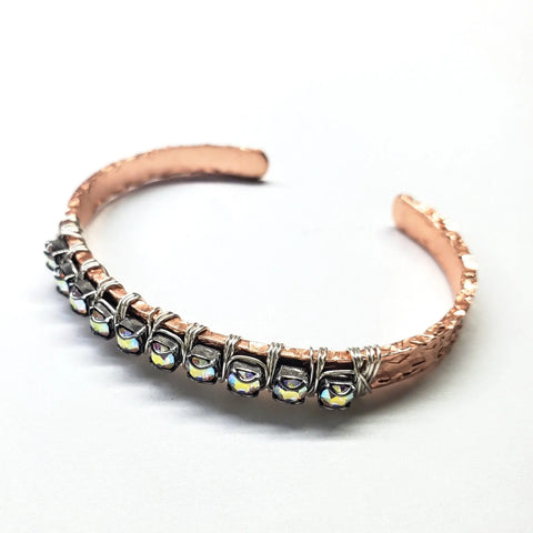 The Set of Glamorously Wrapped Hammered Rhinestone Crystal Bling Bangles by Alexa Martha Designs features hammered copper with sparkling crystal rhinestones, evoking artisanal style and elegance, shown against a white background.
