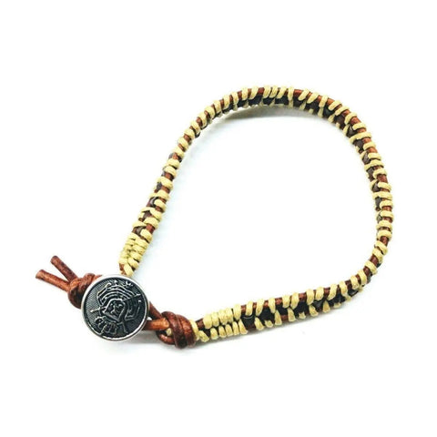 The Alexa Martha Designs Leather Seed Bead Rattlesnake Tail Weave Bracelet features a handcrafted design with braided tan and brown leather cords and a round Tree of Life metallic closure, finished with elegant brown leather ties.