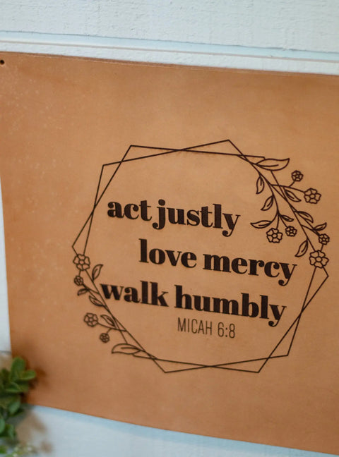 The Urban Southern Act Justly Leather Sign features Micah 6:8—act justly, love mercy, walk humbly—with floral accents. This handcrafted light brown wall decor adds inspiration to any light-colored wall.