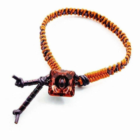 The Orange Purple Leather Beaded Rattlesnake Tail Weave Bracelet by Alexa Martha Designs features a unique braided design with a central amber bead and adjustable beaded ends, showcased on a white background.