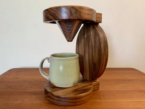 The Rounded Pour Over by Shop Cat Woodworks is a handcrafted kit made from reclaimed wood, featuring a reusable cone filter with a green ceramic mug, perfect for pour-over coffee.