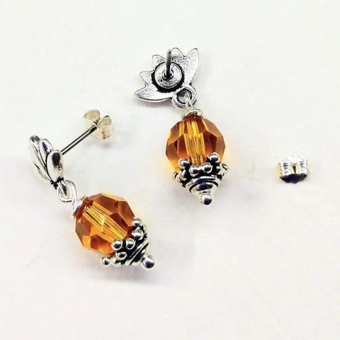 Sterling Silver Crystal Pineapple Studded Earrings by Alexa Martha Designs shown, with one earring flat and the other upright on a white background, plus a separate butterfly backing nearby.