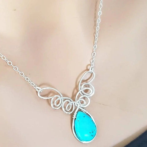 The As Seen on TV Turquoise Drop Sterling Silver Wire Wrapped Necklace by Alexa Martha Designs features intricate swirling loops and a teardrop turquoise pendant, beautifully adorning your neck.