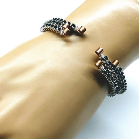 The Alexa Martha Designs Wire Wrapped Copper Silver Black Crystal Rhinestone Bangle is shown on a mannequin hand with a textured chain bracelet, both stackable and displayed against a white background.