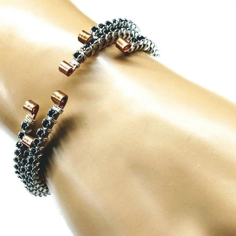 A close-up of the Wire Wrapped Copper Silver Black Crystal Rhinestone Bangle by Alexa Martha Designs, featuring textured copper and silver wire details, showcased on a mannequins wrist against a white background.