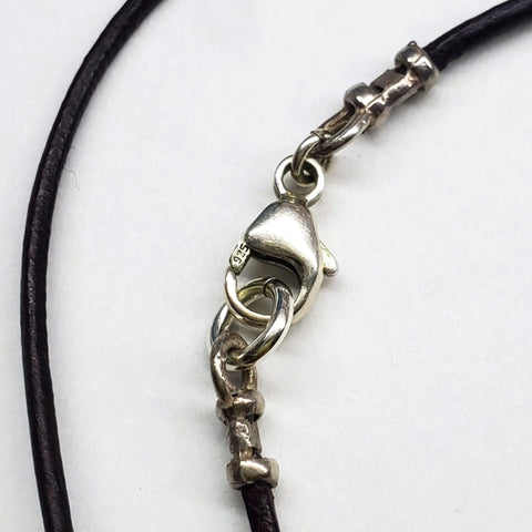 Close-up of a silver lobster clasp with dark brown leather cords and silver connectors from the Alexa Martha Designs Wire Wrapped Open Heart Crystal Necklace, showcased against a white background for an elegant touch.