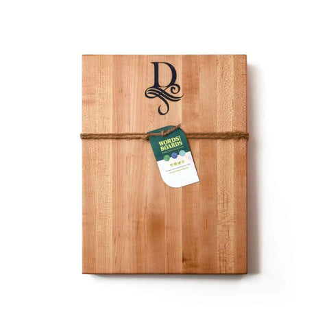 The Handcrafted Wooden Cutting Board by Words with Boards features a monogram with stone inlay and makes a perfect personalized gift, finished with twine and a green World’s Best Boards tag, displayed on a white background.