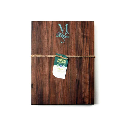 The Handcrafted Wooden Cutting Board by Words with Boards features a monogram with stone inlay, making it a unique personalized gift. Made in the USA, its beautifully presented and perfect for special occasions.