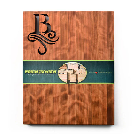 Handcrafted Wooden Cutting Board – Single Initial Monogram by Words with Boards: a rectangular board featuring a decorative initial cutout, wrapped in a green label—perfect as a personalized gift and stylish kitchen accessory. Made in USA.
