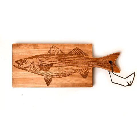 The Handcrafted Wooden Fish Shaped Cutting Board by Words with Boards features a detailed etched illustration and metal hook, making it unique kitchenware. Made in the USA, shown against a plain white background.