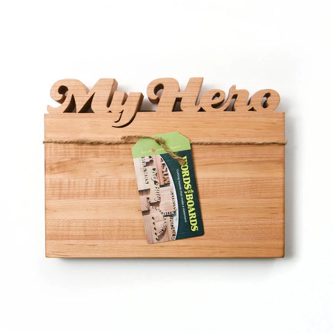 The Handcrafted Wooden Personalized Cutting Board (Small) by Words with Boards features a decorative My Hero sign, rope accent, and branded tag—perfect as a unique gift or stylish kitchen accessory. Made in the USA.