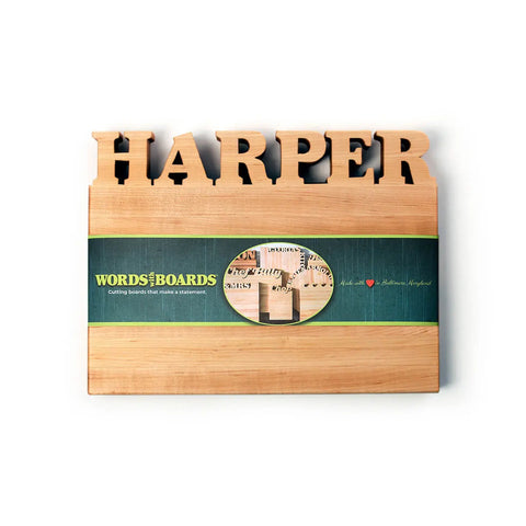 A practical kitchen accessory, the Words with Boards Handcrafted Wooden Personalized Cutting Board (Small) features a custom name carved along the top edge and a green label with product image and branding. Made in the USA.