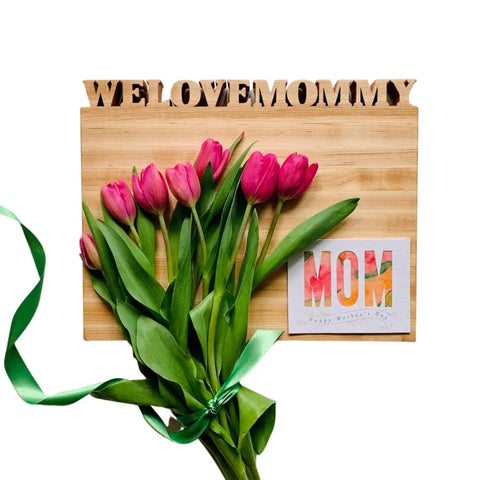 A large personalized cutting board with flowers lying on top of it. This American-made board can be customized with a loved ones name. 