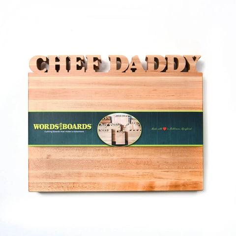 The Handcrafted Wooden Personalized Cutting Board – Large by Words with Boards is made in the USA from American hardwoods, features CHEF DADDY engraved at the top, and comes with a signature green Words with Boards label around the middle.