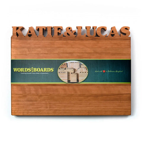 The Handcrafted Wooden Personalized Cutting Board – Large by Words with Boards, made in the USA from American hardwoods and engraved with “KATIE & LUCAS,” is perfect for kitchen display and gifting.