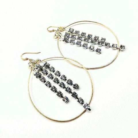 Golden Oval Hoop Crystal Chain Earrings by Alexa Martha Designs feature three vertical chains of sparkling crystals inside each gold-filled hoop, shown on a white background.