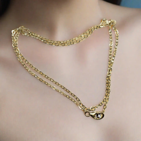A close-up of a neck wearing the Alexa Martha Designs Super Sparkly Crystal Pillar Pendant in green, blue, and rose on a necklace. The background is softly blurred.