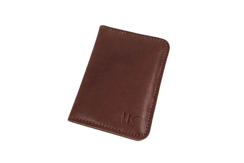 The Urban Southern Passport Wallet is a closed brown full-grain leather wallet with visible stitching and an embossed logo, photographed against a white background—an elegant travel companion for your essentials.